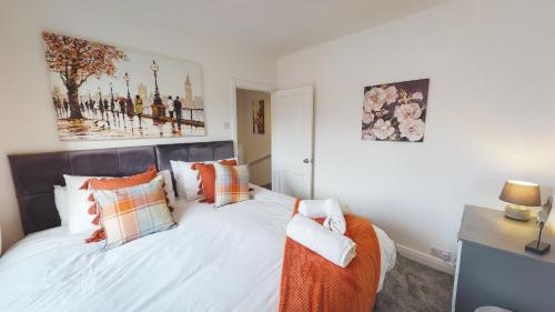 a bedroom with a bed with orange and white pillows at Stunning 3-Bed house in Chester by 53 Degrees Property, ideal for Contractors & Families, FREE Parking - Sleeps 7 in Chester