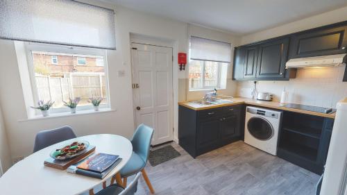 a kitchen with a table and a sink and a washing machine at Stunning 3-Bed house in Chester by 53 Degrees Property, ideal for Contractors & Families, FREE Parking - Sleeps 7 in Chester