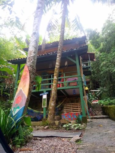 dom z deską surfingową przed nim w obiekcie Camping Trópico de Capricórnio - Ilhabela w mieście Ilhabela