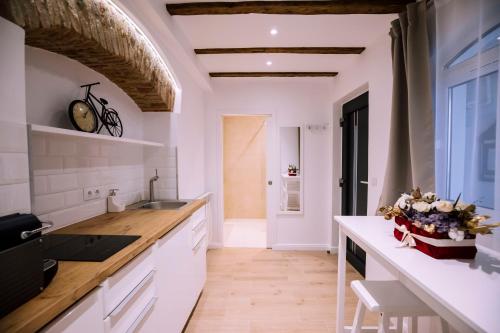 a kitchen with white cabinets and a large window at Chic Central Studio in Sibiu