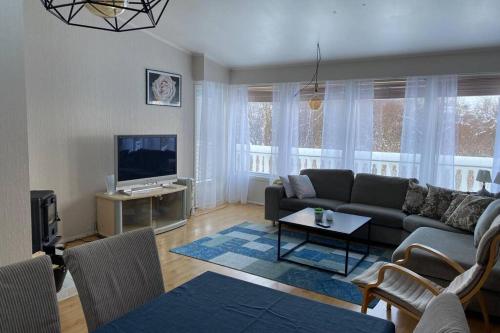 een woonkamer met een bank en een tv bij Koselig hus til leie på Stokmarknes i Vesterålen in Stokmarknes