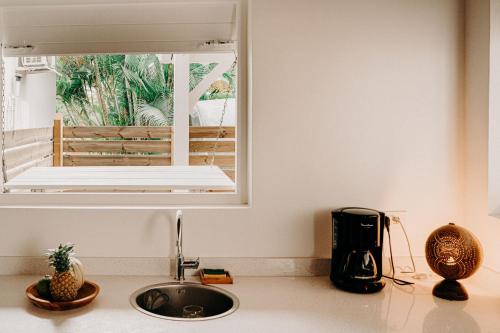 a kitchen counter with a sink and a window at Nid Kreyol in Sainte-Anne