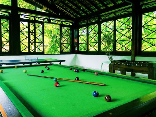 a green pool table with billiard balls on it at Casa Maresias Canto do mar - 50m da praia in Maresias