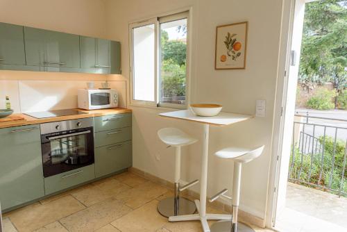 a kitchen with green cabinets and a counter with a microwave at Boulevard du Soleil in Bormes-les-Mimosas