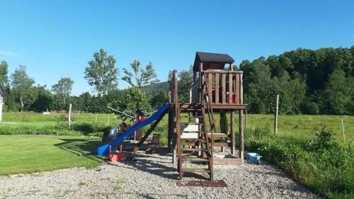 a wooden playground with a slide and a slideintend at Apartamenty Malinówka pod Śnieżką in Kowary