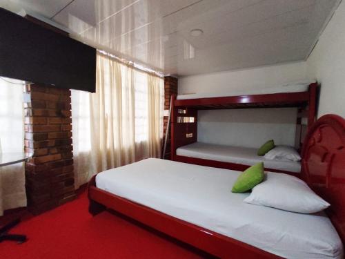 a bedroom with two bunk beds and a red carpet at Hotel Casablanca Cañaveral in Floridablanca