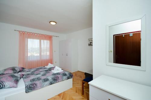 a bedroom with a bed and a mirror at Apartments Marija & Lino in Lopar