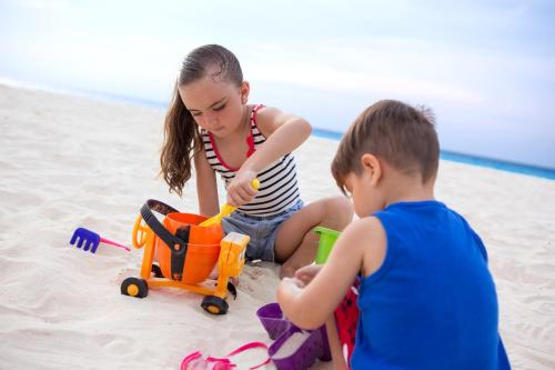 two children playing in the sand on the beach at Hard Rock Hotel Riviera Maya - All Inclusive in Puerto Aventuras