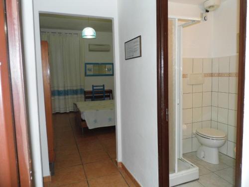 a bathroom with a toilet and a sink in a room at Lina Hotel in Stintino