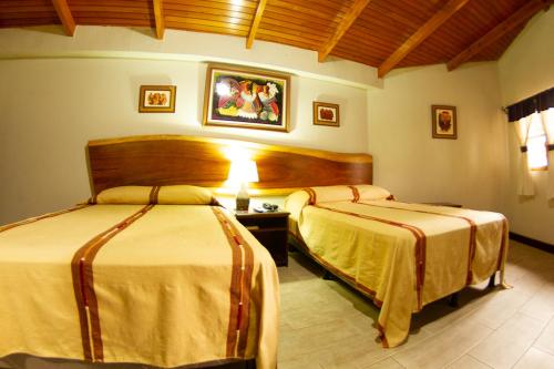 a hotel room with two beds in a room at Hotel Dos Mundos Panajachel in Panajachel