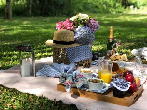 una mesa de picnic con comida y una botella de vino en Pousada Natureza Serrana, en Urubici