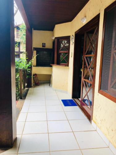an entrance to a house with a tiled floor and doors at Casa Maresias Canto do mar - 50m da praia in Maresias