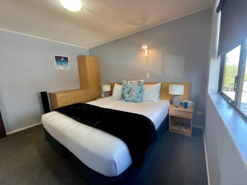 a bedroom with a large bed and a window at Hacienda Motor Lodge in Palmerston North