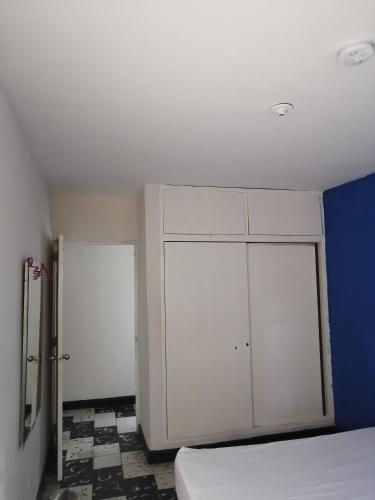 a bedroom with white cabinets and a blue wall at Selvática Alojamiento Eco in Medellín