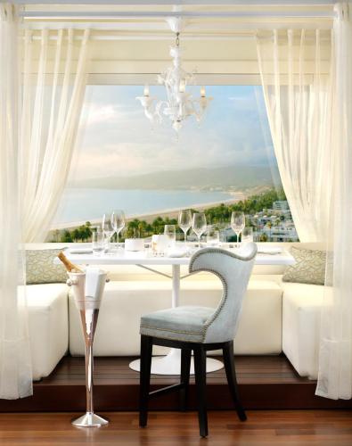 a dining room with a table and a large window at Huntley Santa Monica Beach in Los Angeles