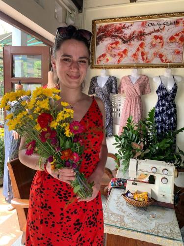 a woman holding a bouquet of flowers in a store at Cherry Garden Homestay in Hoi An