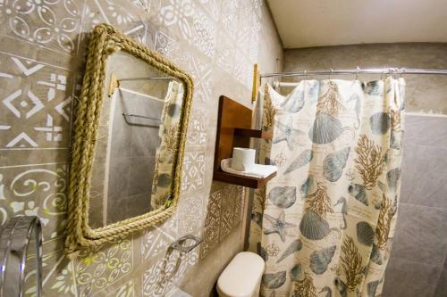 een badkamer met een spiegel en een toilet bij Costa Esmeralda in El Cuyo