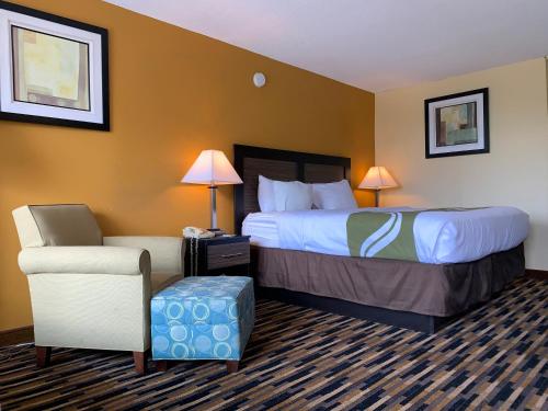 a hotel room with a bed and a chair at Quality Inn University Area in Troy