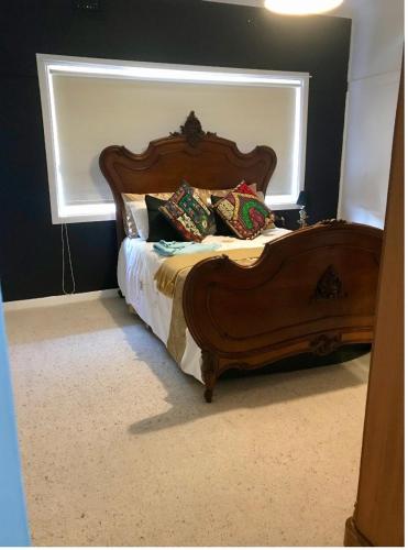 a bedroom with a wooden bed with a window at Parker st in Cootamundra