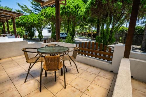 a patio with a table and chairs and a fence at Sheep House B&B in Jian