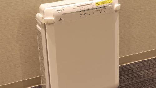 a white refrigerator freezer sitting next to a wall at JR Inn Sapporo in Sapporo