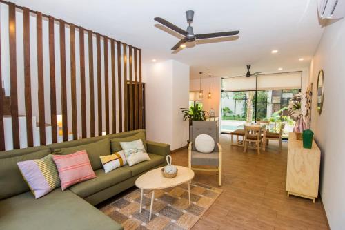 a living room with a green couch and a table at Tannah Luxury Rentals in Mérida