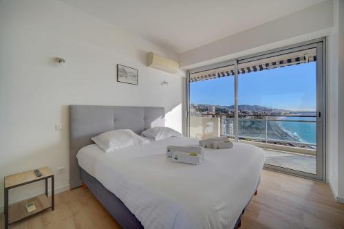 une chambre avec un grand lit blanc avec une grande fenêtre dans l'établissement IMMOGROOM- Incredible View -4- Big Terrace - AC - Parking, à Cannes