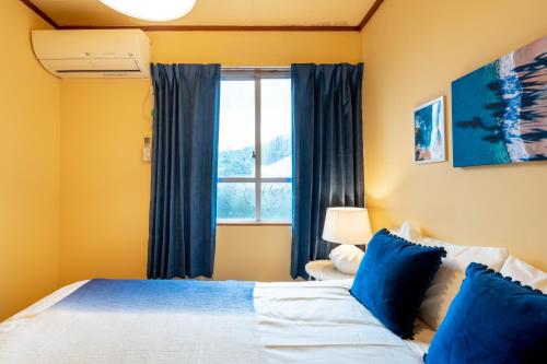 a bedroom with a bed and a window at Deluxe Room 130平米 URUMAHOTEL in Uruma
