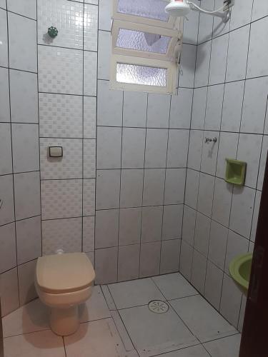 uma casa de banho branca com um WC e uma janela em Apartamento mobiliado no Canto do Forte - Praia Grande - SP Férias, temporada, feriados em São Paulo