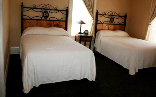 
a bedroom with two beds and two lamps at Hotel Eklund in Clayton
