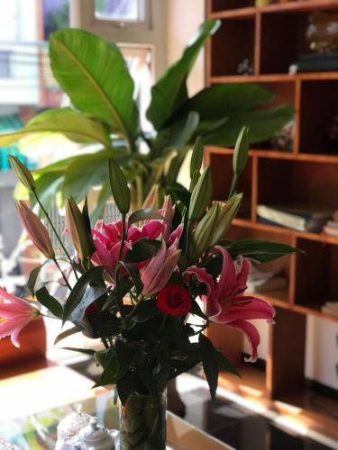 a vase filled with pink flowers on a table at Hotel Hoàng Hưng Quy Nhơn in Quy Nhon
