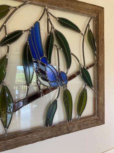 a stained glass window in a wooden frame on a wall at Daysy Hill Country Cottages in Port Campbell