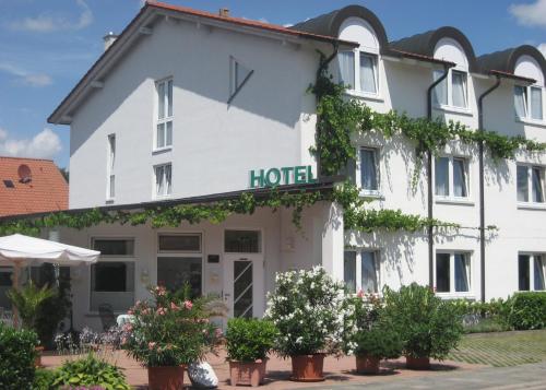 a hotel with plants in front of it at Lindner's Hotel in Bellheim