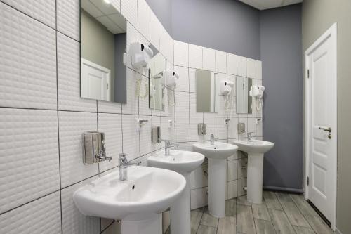 a bathroom with two sinks and two mirrors at Scandinavia in Saint Petersburg