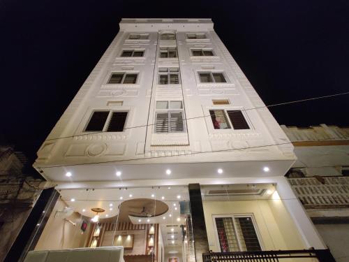 a tall white building with a lot of windows at Hotel City Palace in Varanasi