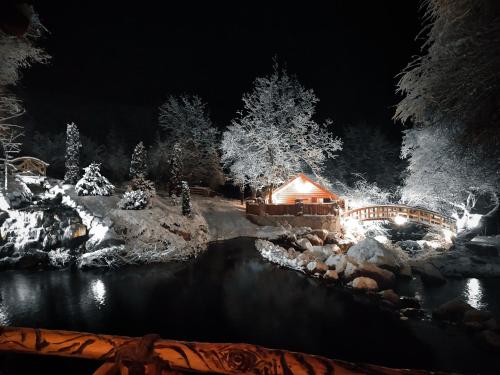 a christmas display of a house and a river at night at Getahovit Resort in Ijevan