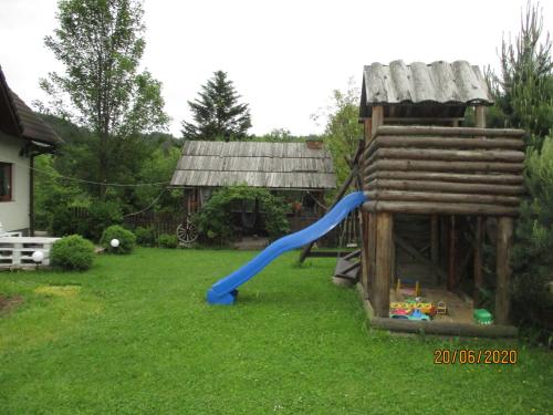 un parco giochi con scivolo blu in un cortile di Agroturystyka nad brzegiem a Kacwin