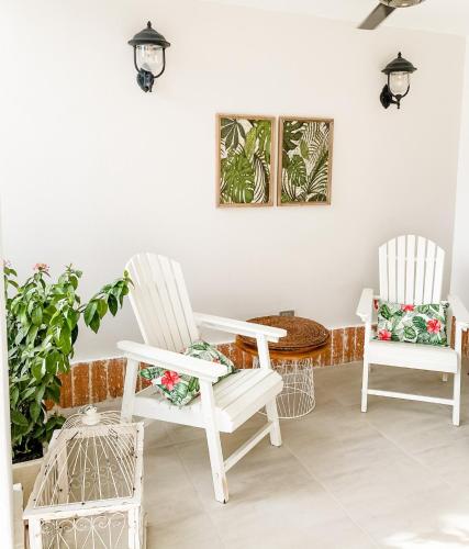 two white chairs and a table on a porch at Casa Bixa Hotel Boutique by HMC - Mayores de 12 años - in Santa Fe de Antioquia