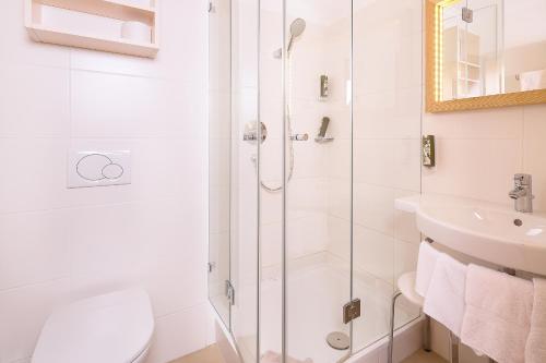 a bathroom with a shower and a toilet and a sink at Alpenrose Kufstein in Kufstein