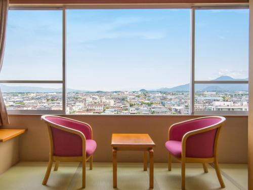 two chairs and a table in front of a window at Tendo Hotel in Tendo