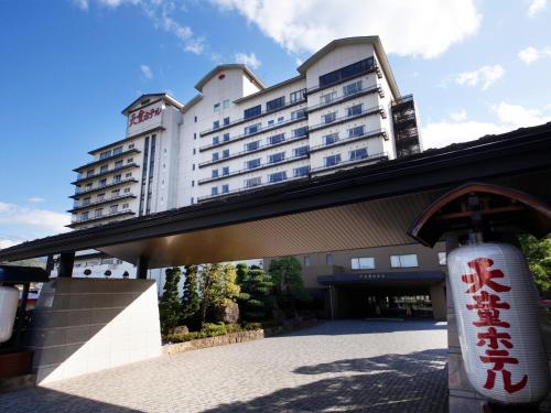 a large white building with a sign in front of it at Tendo Hotel in Tendo
