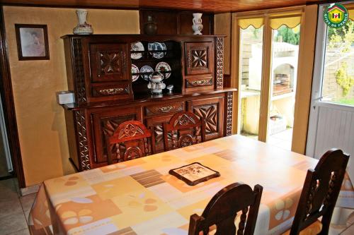Maison de 2 chambres avec terrasse et wifi a Longvilliers في Longvilliers: غرفة طعام مع طاولة وخزانة خشبية