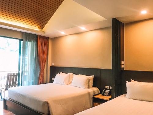 a hotel room with two beds and a phone at Aonang Hill Krabi-SHA Extra Plus in Ao Nang Beach