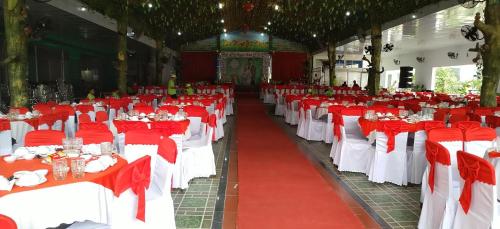 a large room with red and white tables and chairs at Khách Sạn Ngọc Hân in Tinh Bien