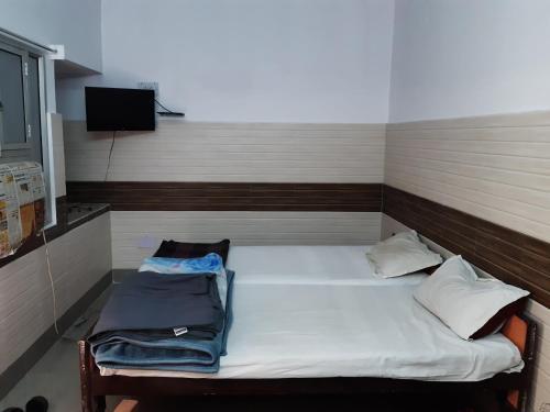 a small bed in a room with a tv at Hotel Yuvraj in Patna