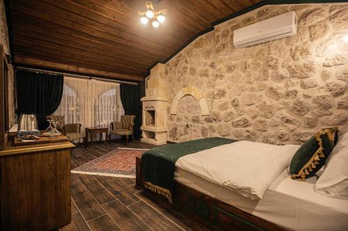 a bedroom with a bed and a stone wall at Göreme Rock Cave in Göreme