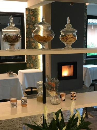 a fireplace in a dining room with a table and chairs at EcoHotel Ristorante Milano in Borgo a Mozzano