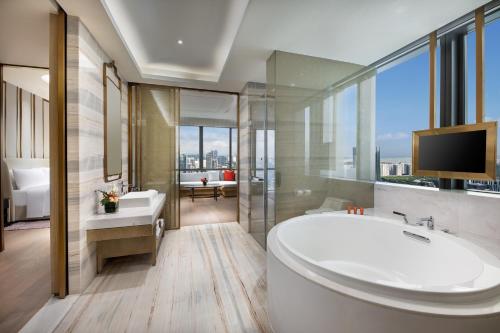 a bathroom with a tub and a sink and a tv at Crowne Plaza Shenzhen Nanshan by IHG in Shenzhen