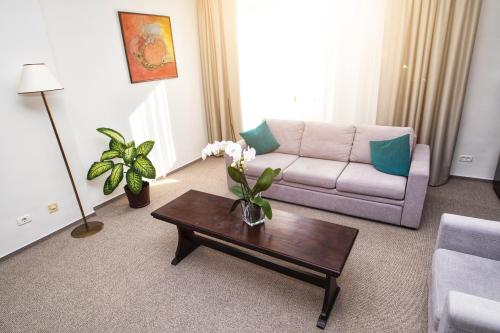 a living room with a couch and a coffee table at International Bucharest City Centre Hotel in Bucharest