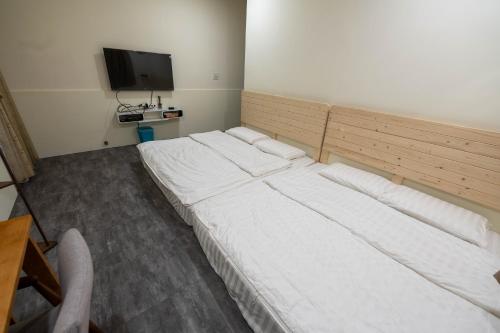 a large white bed in a room with a television at Daily Home in Xiaoliuqiu